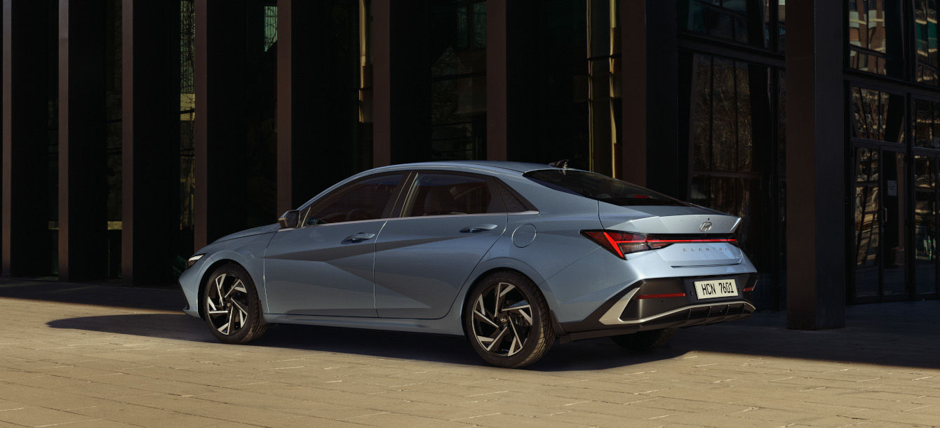 Side-front view of orange Grandi10 with lakeside view at night