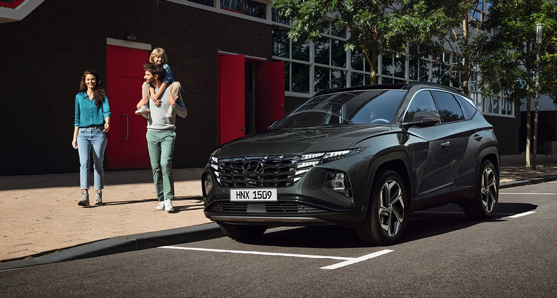 Side-front view of orange Grandi10 with lakeside view at night