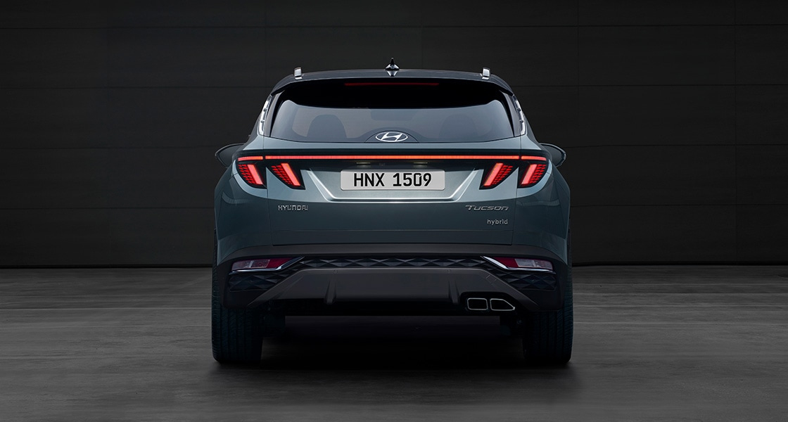 Side-front view of orange Grandi10 with lakeside view at night